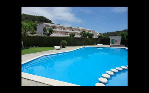 塔马里特Cala Azul 304-306 Tamarit的一座蓝色的大型游泳池,其建筑背景为: