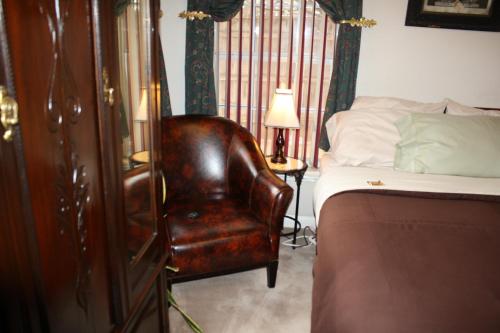 拉伯克伍德罗住宿加早餐旅馆的一间卧室配有床和棕色皮椅