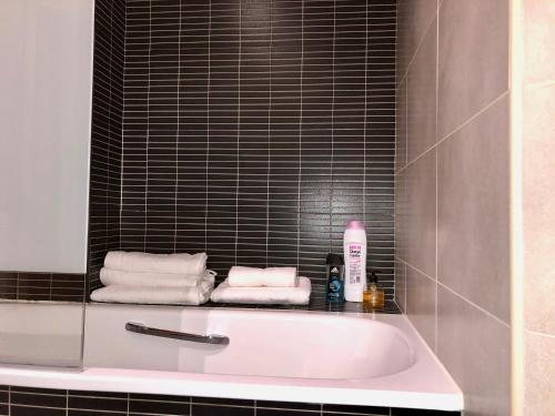 奥维多Apartamento Europa Jardín的浴室配有浴缸和毛巾。
