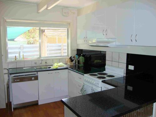 布赖特Ageri Holiday House的一间厨房,配有白色家电和大窗户