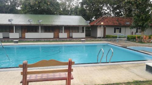 KilinochchiFriends Paradise的房屋前带长凳的游泳池