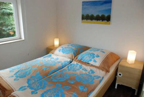 奥斯特巴德·哥伦Ferienbungalow in Goehren的一间卧室,床上摆放着蓝色鲜花