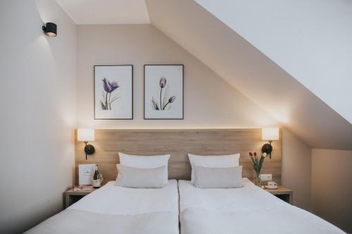 詹塔尔Tulipanowy Gościniec的卧室配有两张床,墙上挂着紫色的鲜花