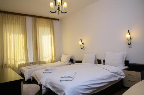 兹拉托格勒Hotel Zlatograd的配有白色床单的客房内的两张床