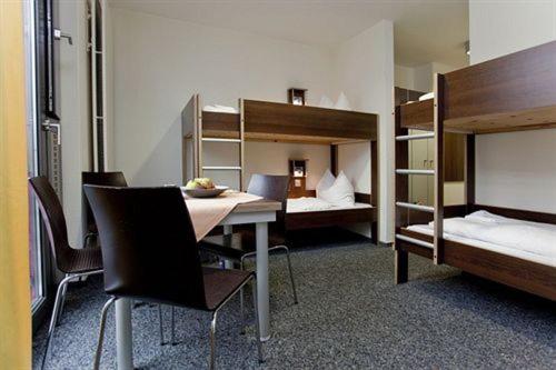 杜塞尔多夫杜塞尔多夫青年旅馆的客房设有桌椅和双层床。