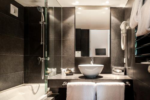 阿维尼翁克鲁尔特圣路易斯阿维农酒店的浴室配有盥洗盆和浴缸。