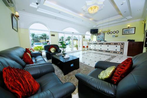 马斯喀特马斯喀特国际酒店的客厅配有黑色真皮沙发和电视