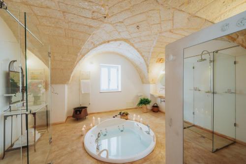 蒙塔尔巴诺马塞里亚安雪拉酒店的一间设有天花板的客房内设有带浴缸的大浴室