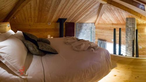 圣博沃内尔多奇谢尔木屋酒店的小木屋内一间卧室,配有一张床