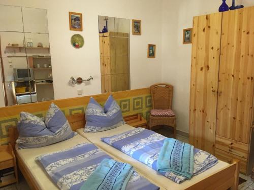 艾普莱尼Bakonyi Apartmanház Eplény的一间卧室配有两张带蓝色枕头的床