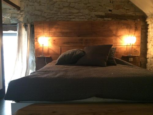 LozeLa Maison Du Meunier的一间卧室配有一张大床和两盏灯