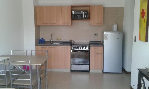 维纳德马Departamento Atlántico 4030的厨房配有木制橱柜和白色冰箱。