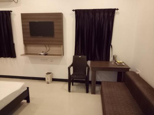 哥印拜陀ComfortWings的客房设有书桌、桌子和电视。
