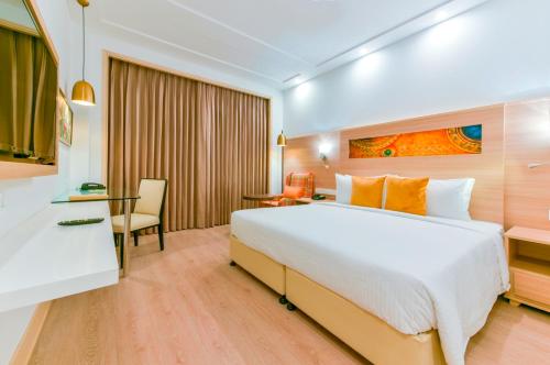 贾姆穆Lemon Tree Hotel Jammu的酒店客房设有一张大床和一张书桌。