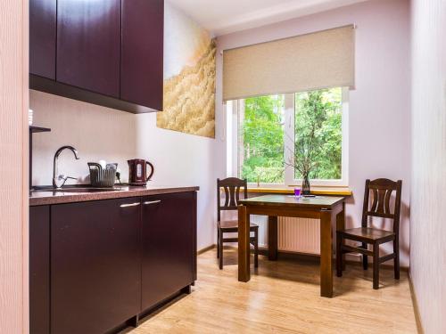 尤尔马拉KEMERI Hotel in National Park - FREE PARKING的厨房以及带桌子和窗户的用餐室。