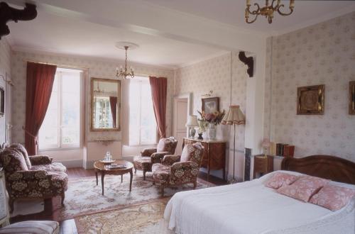 Chartrettes鲁永德雷斯特城堡旅馆的卧室配有一张床和一张桌子及椅子