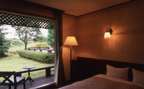 那须町Canari的卧室设有窗户,享有庭院的景色