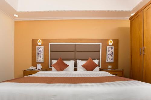 延布Hotel Ritaj Alsahel的一间卧室配有一张带橙色墙壁的大床