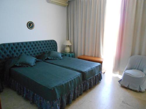 多列毛利诺斯CASTILLO DE SANTA CLARA 2的一间卧室配有蓝色的床和椅子