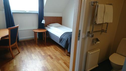 Hillerstorp哈加酒店的小房间设有一张小床和一张桌子