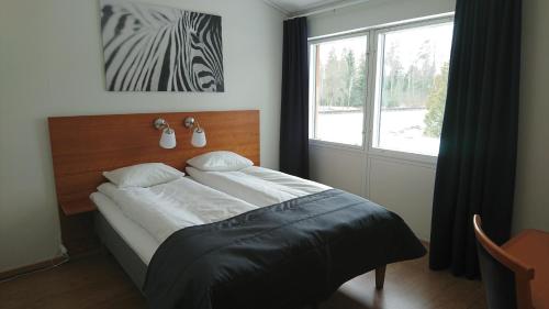 Hillerstorp哈加酒店的一间卧室设有一张大床和大窗户