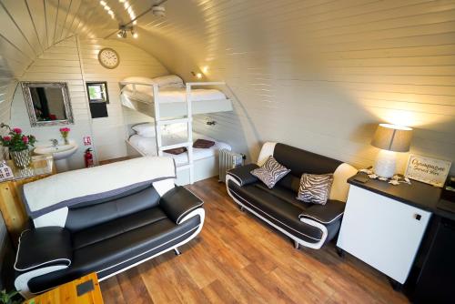 弗罗德舍姆Deluxe Glamping Pod with Hot Tub的一间小房间,配有沙发和一张双层床