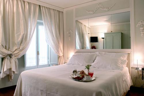 锡耶纳依波娜坎伯吉奥瑞拉斯酒店的一张白色的床,上面有一盘食物