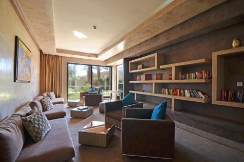 马拉喀什希洛岩精品酒店及马拉喀什Spa的带沙发和书架的客厅