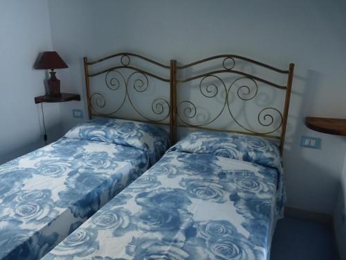 潘泰莱里亚Dammuso Kania alta的一间卧室配有蓝色和白色床单