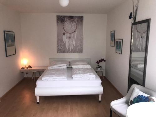 巴登-巴登乌斯巴赫客房民宿的卧室配有白色的床和椅子