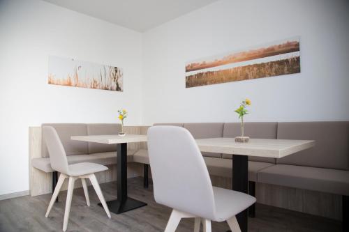 伊尔米茨Gästehaus Pusztablick的餐厅里设有两把白色椅子和一张桌子