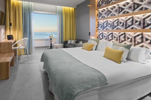拉克鲁斯Hotel Atlantic Mirage Suites & SPA - ADULTS ONLY的一间卧室设有一张大床,享有海景