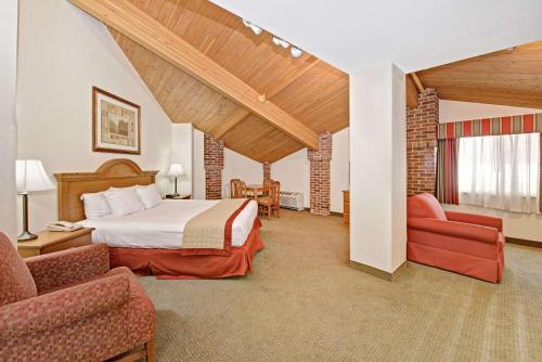 印第安纳波利斯印第安纳波利斯贝蒙特套房酒店的酒店客房,配有一张床和两把椅子