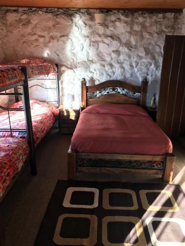 阿基塔尼亚San Rafael de Guaquira的一间卧室设有两张床和石墙
