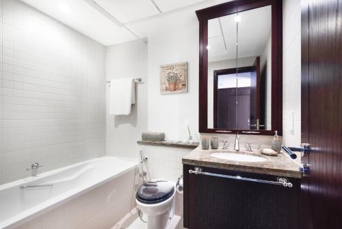 迪拜One Bedroom Apartment Dubai Fountain & Old Town View by Auberge的浴室配有卫生间、盥洗盆和浴缸。