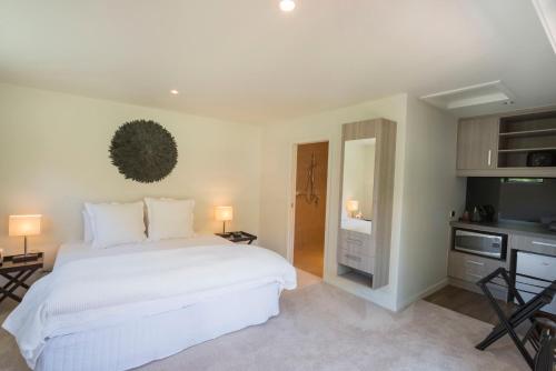 PoukawaSavana Estate的卧室配有一张白色大床和电视。