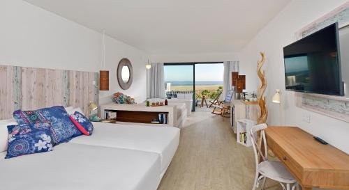 科斯塔卡玛INNSiDE by Meliá Fuerteventura – Adults Only的一间白色的房间,配有床和饭厅