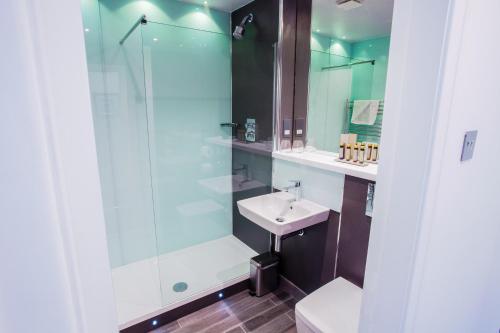 Walmersley红厅酒店的一间带玻璃淋浴和水槽的浴室