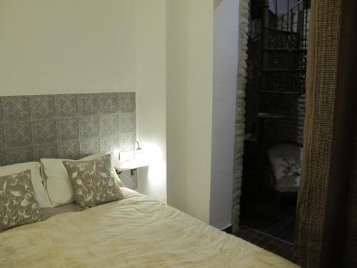 塞维利亚The Green Balcony的一间卧室配有一张带床头板和灯的床