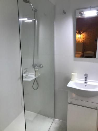 卡拉达沃黄金之家旅馆的一间带玻璃淋浴和水槽的浴室