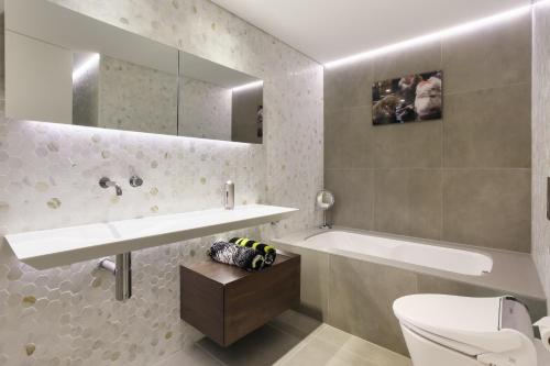 悉尼达令港三卧室公寓的一间带水槽、浴缸和卫生间的浴室
