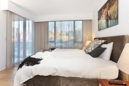 悉尼达令港三卧室公寓的一间卧室设有一张大床和一个大窗户