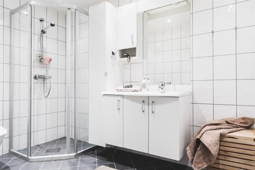 卑尔根Nice, Modern Apartment in Central Bergen的带淋浴和盥洗盆的白色浴室