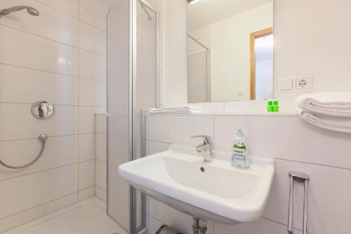 弗莱堡Altstadtloft am Martinstor的白色的浴室设有水槽和淋浴。