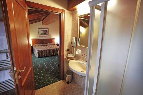 明乔河畔的瓦雷奇奥法西奥里酒店的一间带水槽的浴室和一张位于客房内的床
