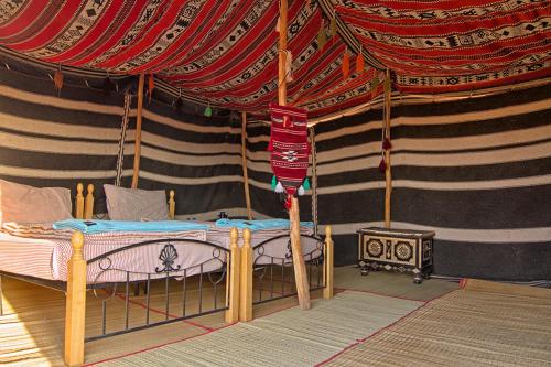Al Wāşil沙漠休闲露营酒店的帐篷内一间卧室,配有一张床