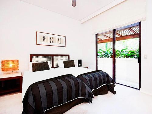 棕榈湾Temple 121 Modern Spacious Palm Cove 2 Brm 2 Bth Resort Apartment With Courtyard的白色的卧室设有一张大床和一个窗户