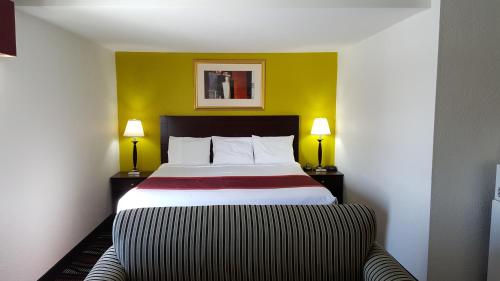 林垦地平线旅馆的酒店客房,配有一张带两盏灯的床