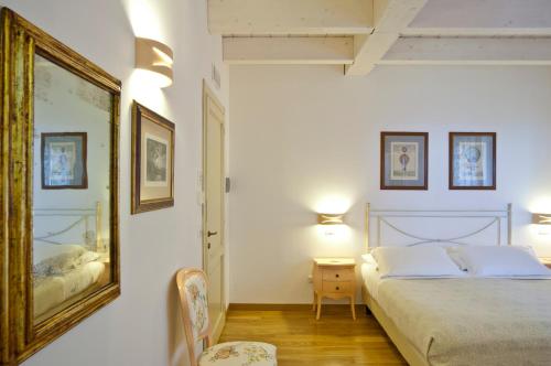 朱利亚诺瓦熊与蜂住宿加早餐酒店的卧室配有一张床,墙上挂着一幅画