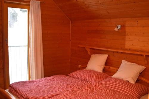 VerditzVerditzhütte的卧室配有木墙内的一张床